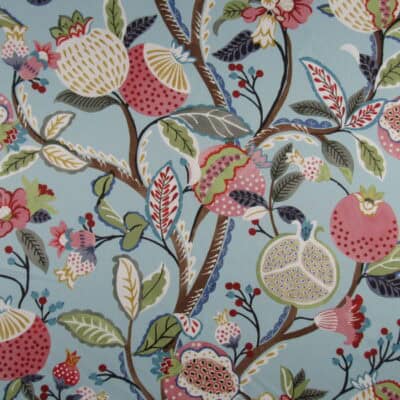 Regal Fabrics Marisol Sky features a charming floral vine pattern with fruit accents in coral, green, and gold, set against a blue background on 100% mercerized cotton